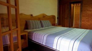 a bedroom with a bed with blue and white sheets at Rancho Curica in Campos do Jordão