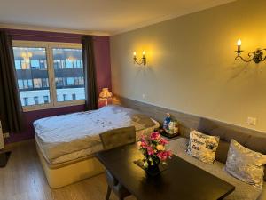 a bedroom with a bed and a table and a couch at ALTAMIRA (Paris Expo - Porte de Versailles) in Issy-les-Moulineaux