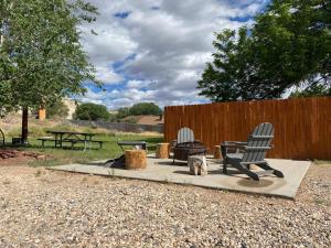 a patio with two chairs and a table and a fire pit at Bryce Canyon Villas in Cannonville