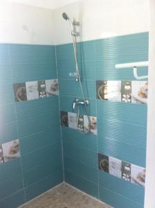 y baño con ducha de azulejos azules. en Villa QUIETUDE, en Sainte-Anne
