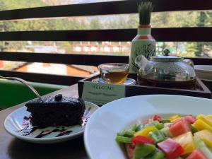 ein Stück Kuchen und ein Salat auf dem Tisch in der Unterkunft The Royal Orchard Kasol in Kasol