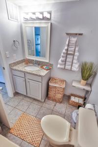 a bathroom with a toilet and a sink and a mirror at stylish luxe condo! in Fort Walton Beach
