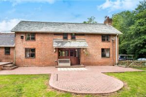 an old brick house with a brick patio at Mill Cottage - Great Houndbeare Farm Holiday Cottages in Aylesbeare