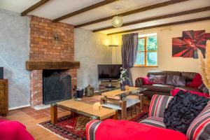 a living room with a couch and a fireplace at Mill Cottage - Great Houndbeare Farm Holiday Cottages in Aylesbeare