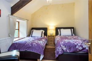 two beds sitting next to each other in a bedroom at Mill Cottage - Great Houndbeare Farm Holiday Cottages in Aylesbeare