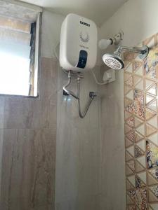 een douche met een haardroger in de badkamer bij Explore Daman in studio flat! in Daman