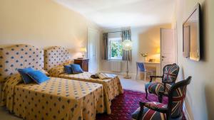 una camera d'albergo con due letti e un tavolo di Tenuta Di Pratello 24, Emma Villas a Peccioli