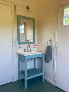 y baño con lavabo azul y espejo. en Hidden Island Hostel en Tigre