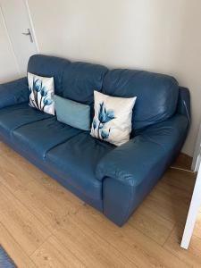 a blue leather couch with three pillows on it at Cosy 3 bed detached house Birmingham in Birmingham