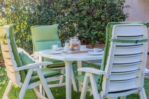 a table with two chairs and a table with a tea set at H11 [Verde Giada] Piscina - Tennis - Parcheggio in Sanremo
