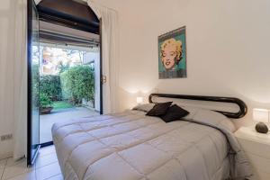 a bedroom with a large bed and a sliding glass door at H11 [Verde Giada] Piscina - Tennis - Parcheggio in Sanremo