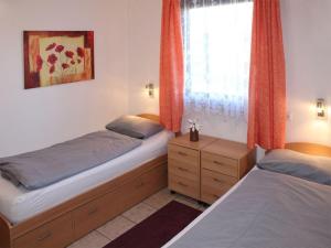 2 camas individuais num quarto com uma janela em Ferienhaus Nr 75, Kategorie Komfort, Feriendorf Hochbergle, Allgäu em Bichel