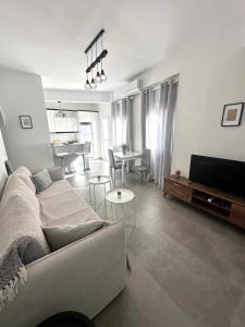 ein Wohnzimmer mit Sofa und Tisch in der Unterkunft White Swallow Suite Santorini in Vourvoúlos