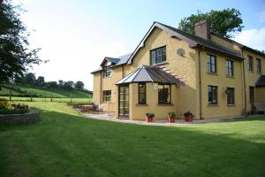 ein großes Haus mit Rasen davor in der Unterkunft Pwllgwilym B & B in Builth Wells