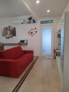 ALBA MOZZAFIATO في لاينوساي: غرفة معيشة مع أريكة حمراء وباب