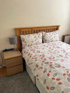 a bedroom with a bed and a nightstand with a bedspread with hearts at Cosy 3 bed detached house Birmingham in Birmingham