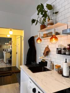 a kitchen with a counter with a sink and pendant lights at Hygge houses I Studio apartment in Lillestrøm I Solo or Couple in Lillestrøm