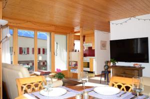 a dining room with a table and a television at Charming and cosy apartment (sleeps 4-6 people) in a beautiful mountain village in Mürren