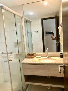 uma casa de banho com um lavatório e uma cabina de duche em vidro. em Beach Class Convention - Boa Viagem no Recife