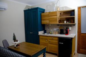a kitchen with a blue cabinet and a table at Marókahegy in Zalakaros