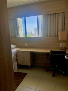 um quarto com uma secretária e uma janela com uma cama em Beach Class Convention - Boa Viagem no Recife
