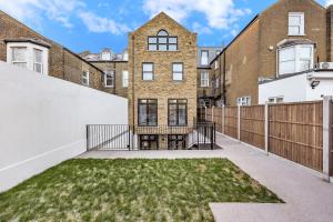 an empty backyard with a fence and grass at Your Cosy Stay Modern 3 Double Bedroom Apartment - Fully Furnished - 5 Mins walk to Stn in London