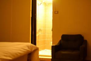 a bedroom with a bathroom with a shower and a chair at Le Caire Guest Hous cairo in Cairo