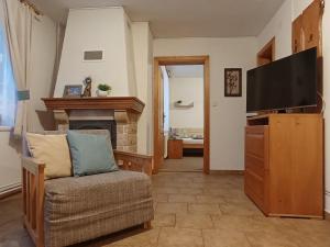 ein Wohnzimmer mit einem Sofa und einem TV in der Unterkunft Apartments Ľubka in Zuberec