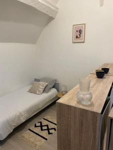 um quarto com uma cama e uma mesa com um vaso em House famille Proche 5´ CDG Roissy Aéroport em Gonesse