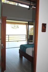 a bedroom with a bed and a large window at Lapazul Boutique Hotel in Savegre