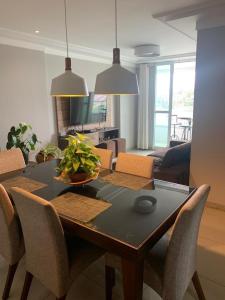 a dining room table with chairs and a living room at LINDO APT 3q FRENTE A PRAIA in Guarapari
