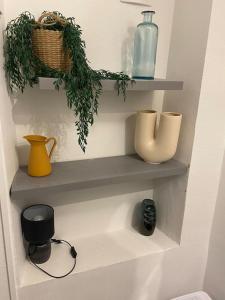 a shelf with pots and vases on it at House famille Proche 5´ CDG Roissy Aéroport in Gonesse