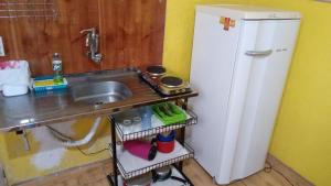 una pequeña cocina con fregadero y nevera. en Quartos ao Lado Expominas, en Belo Horizonte