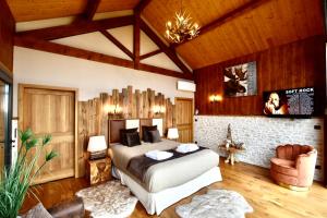 una camera con letto in una stanza con soffitti in legno di L'Orée du Bois du Domaine des Hauts de Rouquette a Eymet