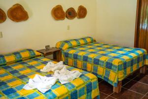 2 camas en una habitación con donuts en la pared en Hotel Cabañas Safari, en Palenque