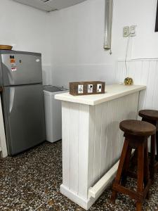 a kitchen with a refrigerator and a counter with stools at Dpto Beltrán in Santa Rosa