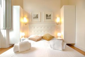 a bedroom with a large white bed with two lamps at Magnifique et lumineux T3 de charme aux Quinconces idéal pour 4 personnes in Bordeaux