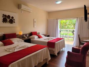 een hotelkamer met 2 bedden en een raam bij Solarium Park Hotel in Adamantina