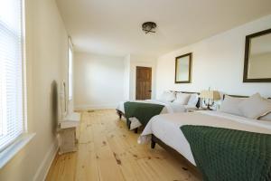 2 letti in una camera bianca con pavimenti in legno di Very Comfy Farmhouse Apartment Unit A, 1st FL a Lancaster