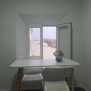 a table and chairs with a view of a beach at Riad Apartment with Panoramic Bouregreg & Marina View in Rabat