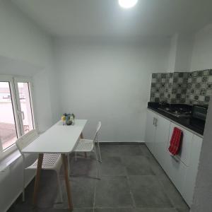a kitchen with a white table and chairs and a table at Riad Apartment with Panoramic Bouregreg & Marina View in Rabat