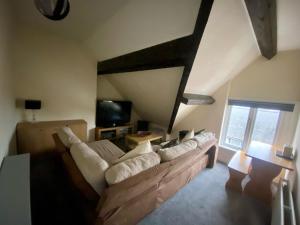 a living room with a couch and a tv at Aisha’s Attic in Rhyl