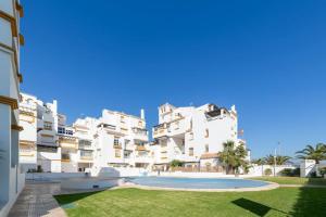 ein großes weißes Apartmenthaus mit einem Pool in der Unterkunft Apartº Roquetas de Mar 1º linea playa in Roquetas de Mar