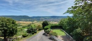 une route descendant une colline avec vue dans l'établissement Maison de vacances vue panoramique le Pailler 4 à 9 personnes, à Millau