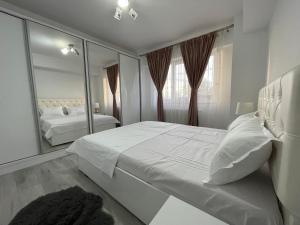 una camera da letto con un grande letto bianco e uno specchio di Traveler’s Luxury Home a Suceava