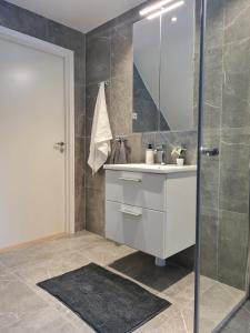 een badkamer met een witte wastafel en een douche bij Three Bedroom Villa Segersjö in Tumba