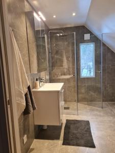 Three Bedroom Villa Segersjö في Tumba: حمام مع حوض ودش