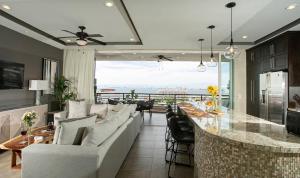 - un salon avec un canapé et une table avec des chaises dans l'établissement Pinnacle Resorts, à Puerto Vallarta