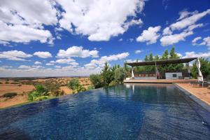 ein Infinity-Pool mit einem Pavillon und blauem Himmel in der Unterkunft Vale Do Manantio in Moura