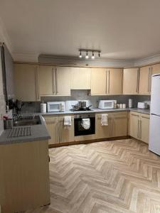 a kitchen with a wooden floor and appliances in it at Gracehill Suite in London